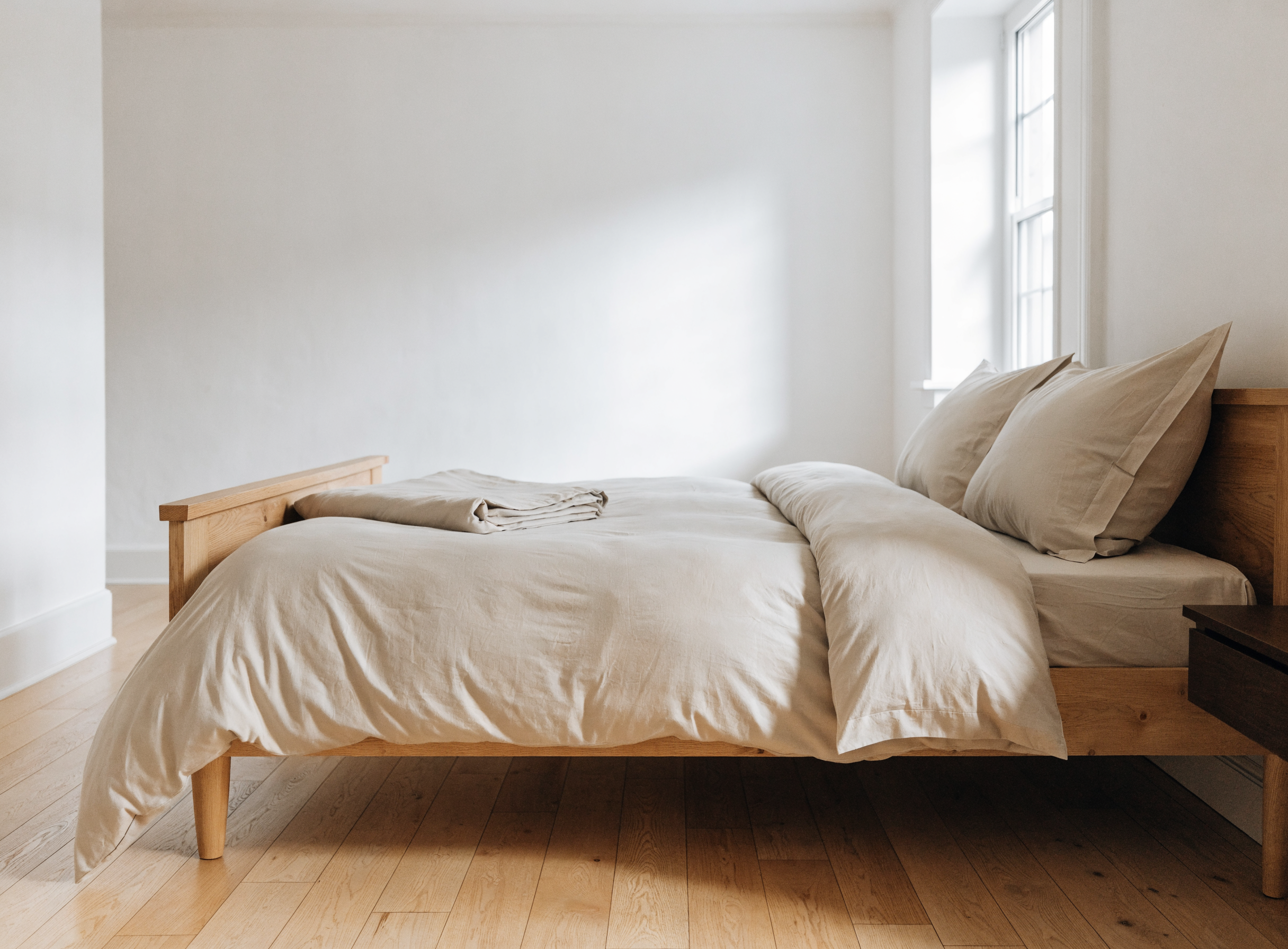 Lit deux places habillé d'une housse de couette beige en coton Image