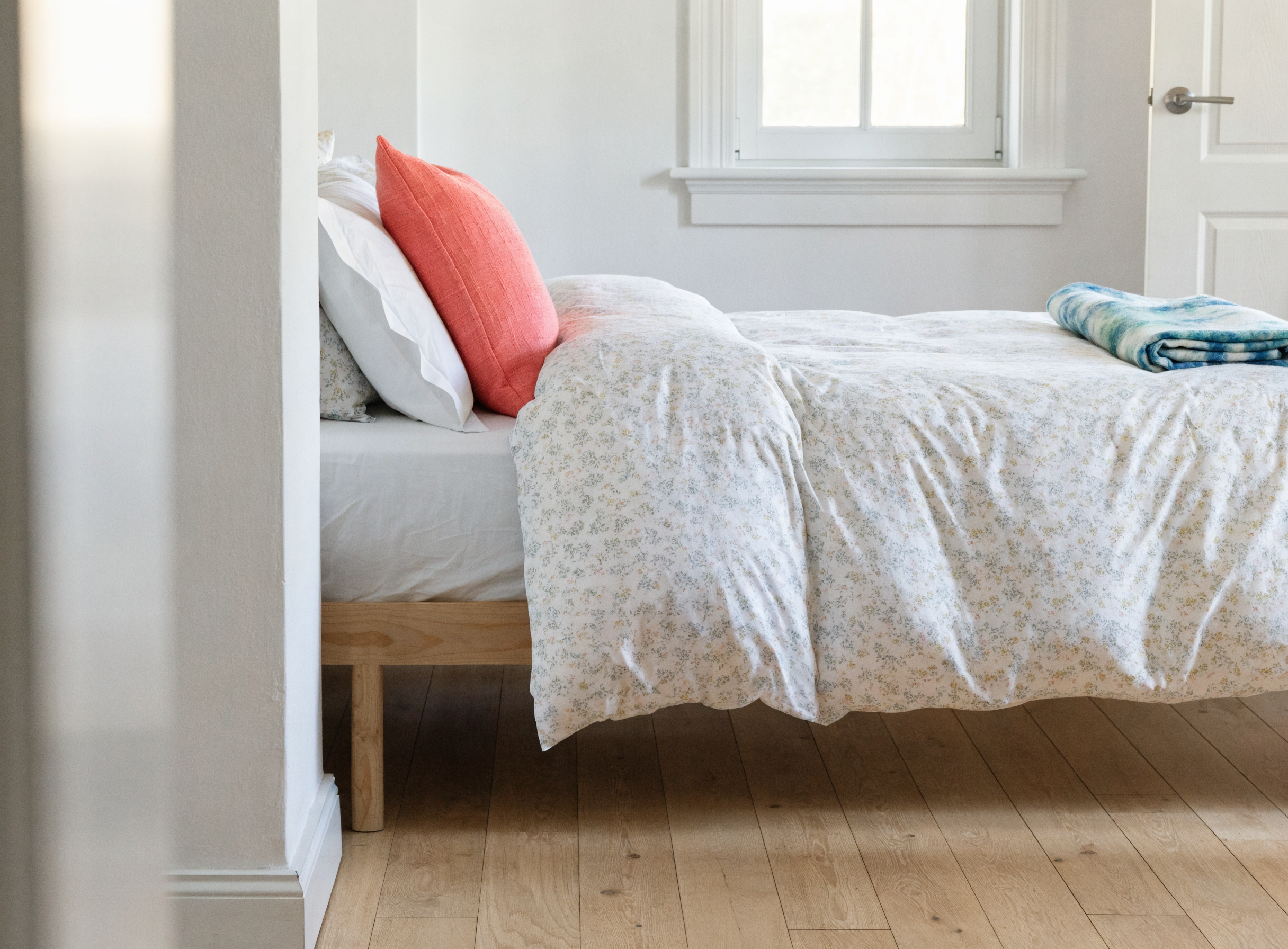Lit habillé d'une housse de couette à motif fleuri aux tons doux